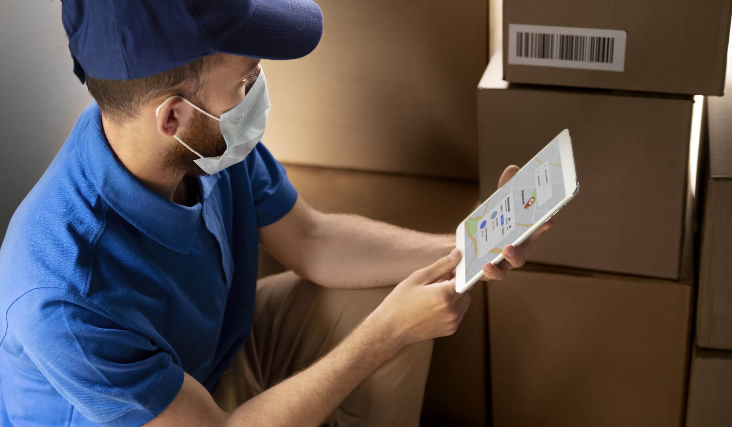 Male warehouse worker using bar code scanner to analyze newly arrived goods for further placement in storage department.
